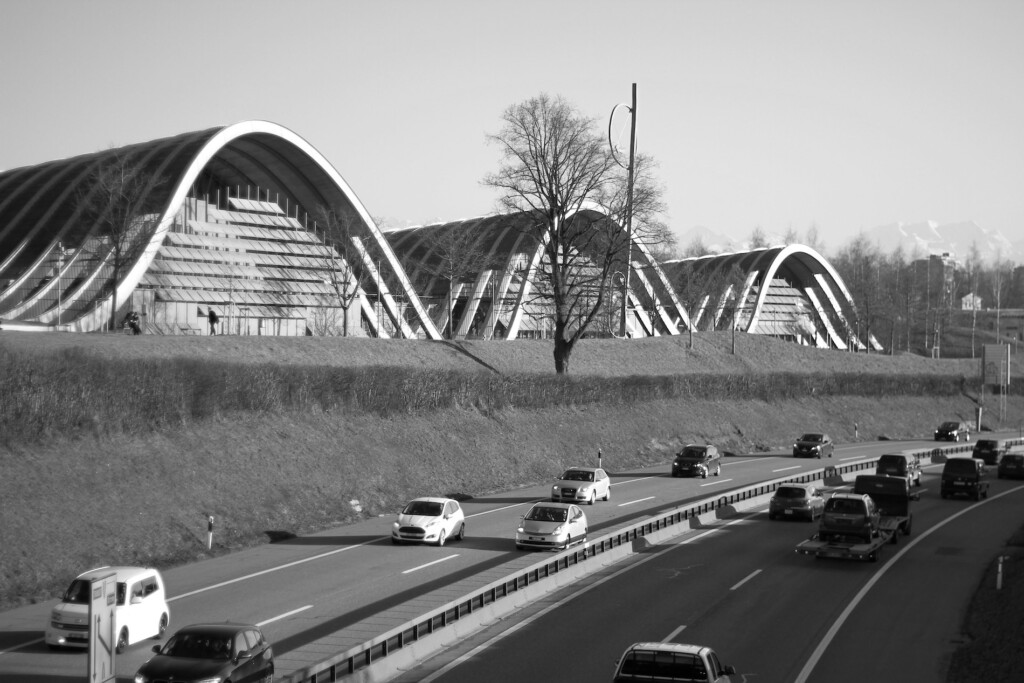 Die drei Wellen des Zentrum Paul Klee schwingen sich über ein Feld und öffnen sich zum Berner Tal.