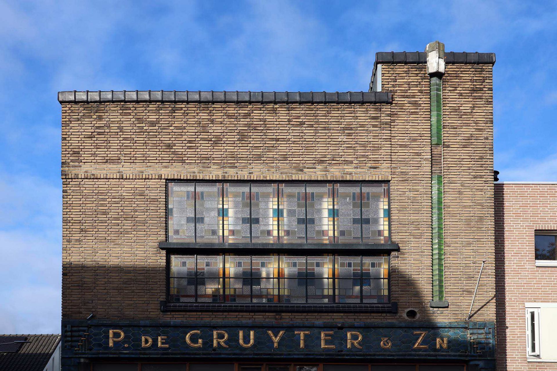 Winkel de Gruyter. Der Entwurf für das stilvolle Ladengeschäft mit Buntglasfenstern und einer schön dekorierten Fassade kommt von W. Welsing, dem Hausarchitekten des renommierten Lebensmittelunternehmens De Gruyter.