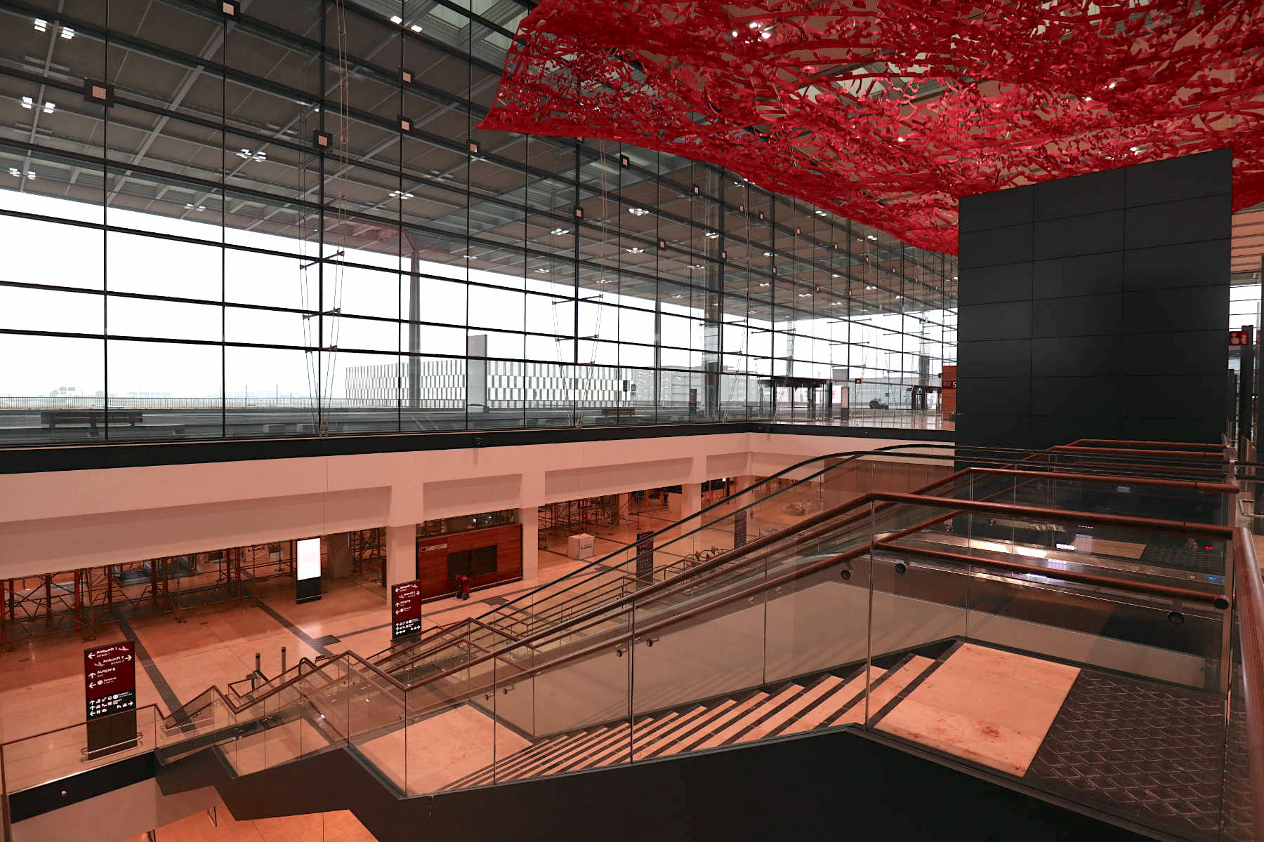Der Übergang vom Flughafenbahnhof und der Haupthalle. Oben: die Installation Magic Carpet.