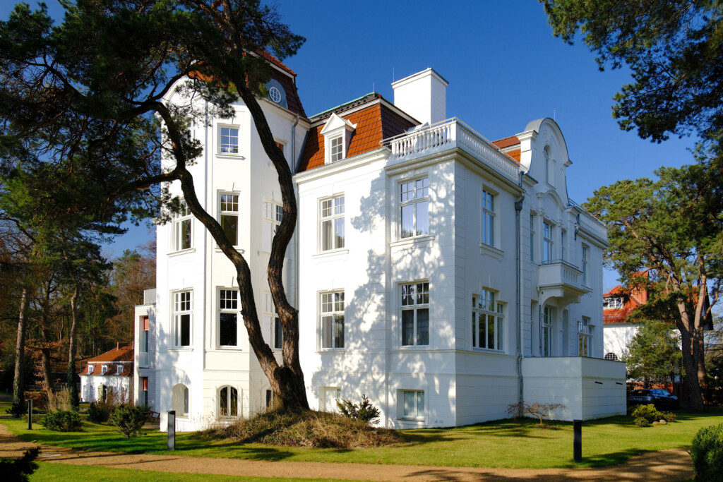 Die sieben Suiten der Pineblue Villas befinden sich in der "Alten Villa", erbaut 1896. Sie steht in erster Reihe direkt am Meer und wurde 2023 aufwendig restauriert. Das historische Mansardendach, der Turm, die Stuckfassade und das mit Schnitzereien verzierte Foyer erstrahlen in neuem Glanz. 