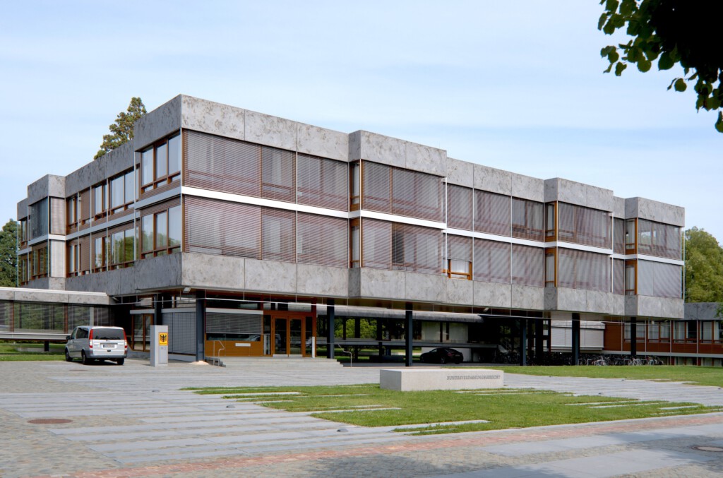 Flache Pavillons, große Glasflächen, präzise Fügung: Die Architektur setzt auf Nähe und Einblick – Rechtsprechung als öffentliche Aufgabe, nicht als Ritual hinter Mauern.
