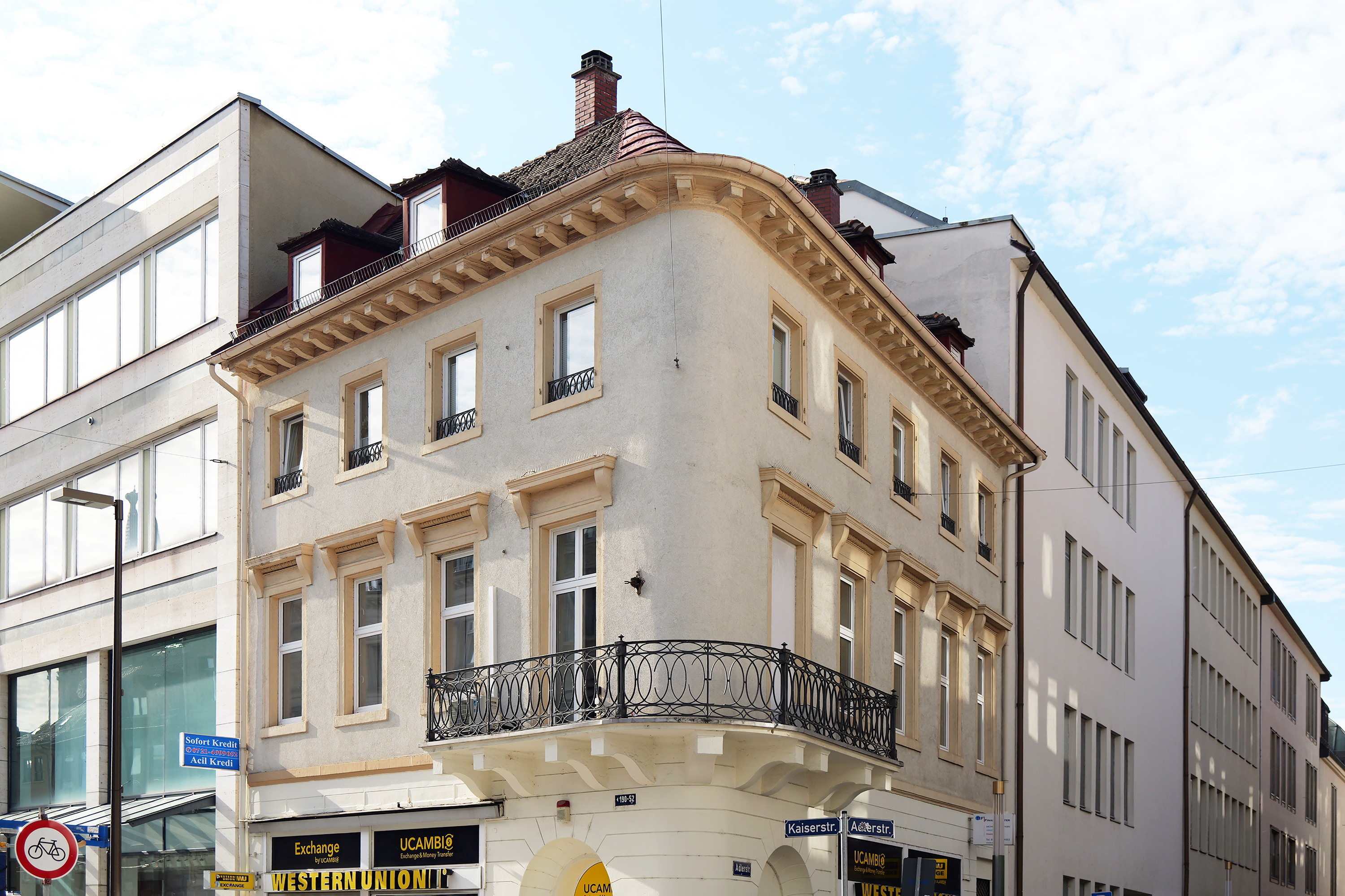 Mit dem Haus Hemberle rückt die Straße selbst in den Blick: Fassade, Ecke, Fenster und die (Un)Ordnung der Häuserreihe.