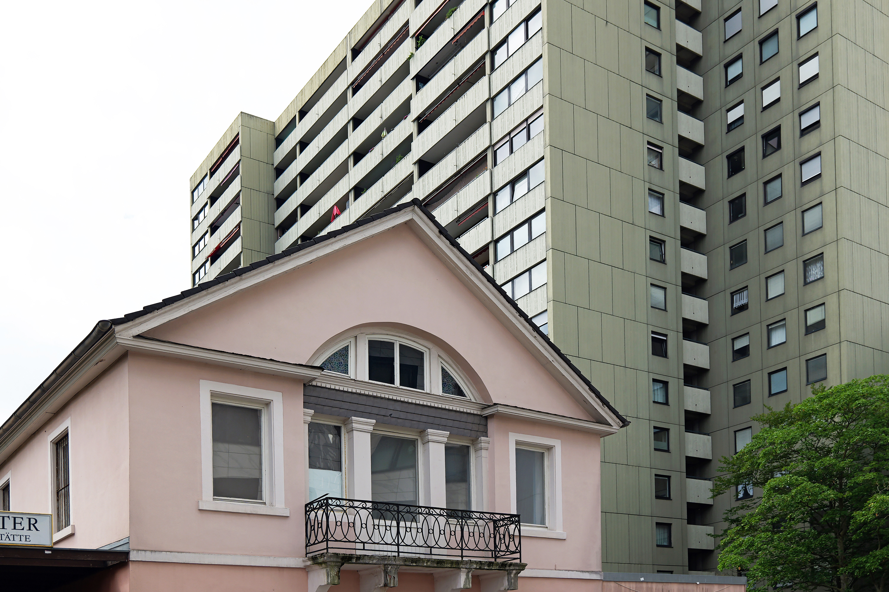 Am Rand der Promenade tritt zwischen Altbau und Wohnblock eine andere Zeitschicht ins Bild.